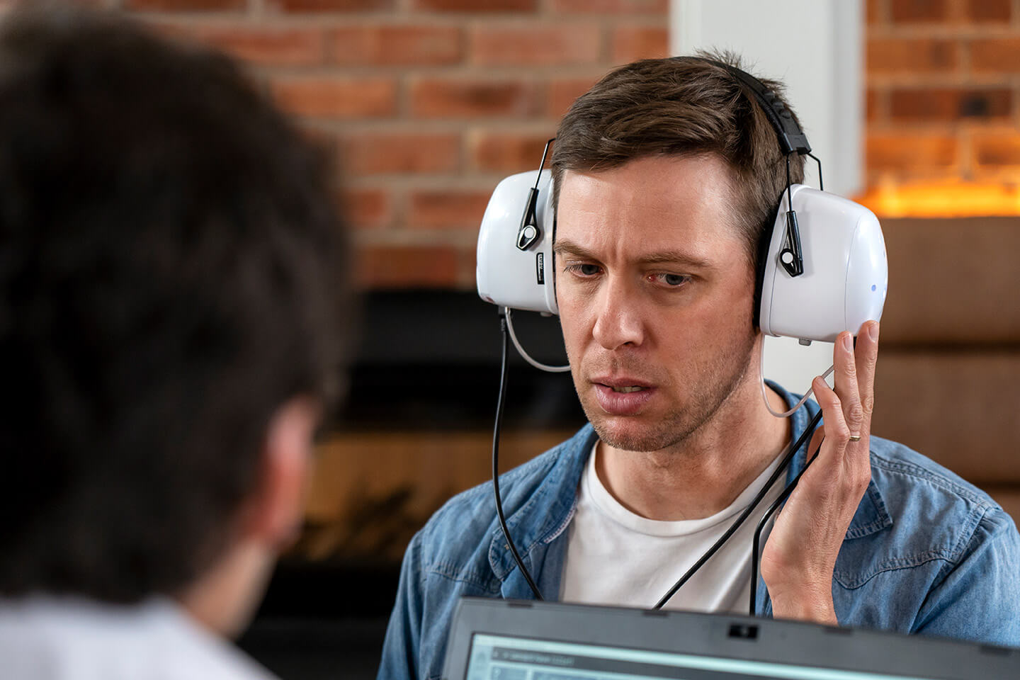 Veteran receiving a hearing screening with a portable Kuduwave audiometer